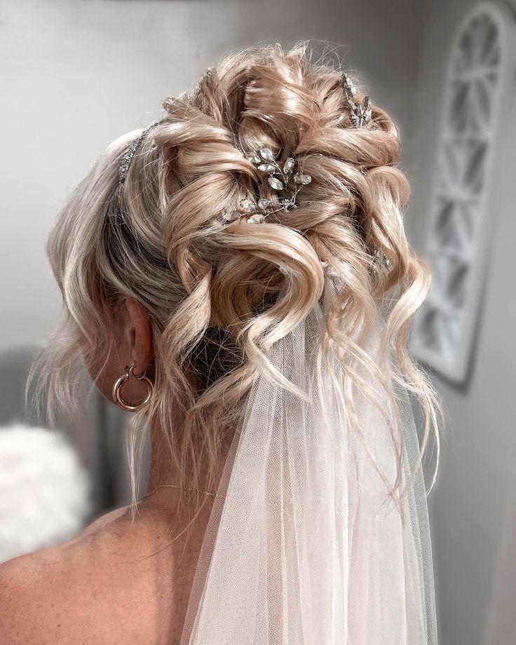 a woman with blonde hair in a wedding dress and veil is looking into the mirror