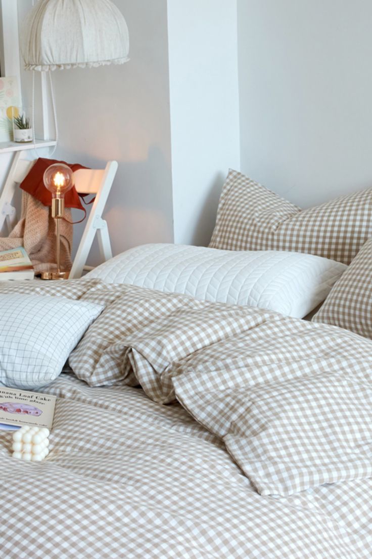 an unmade bed with white and brown checkered comforter on top of it