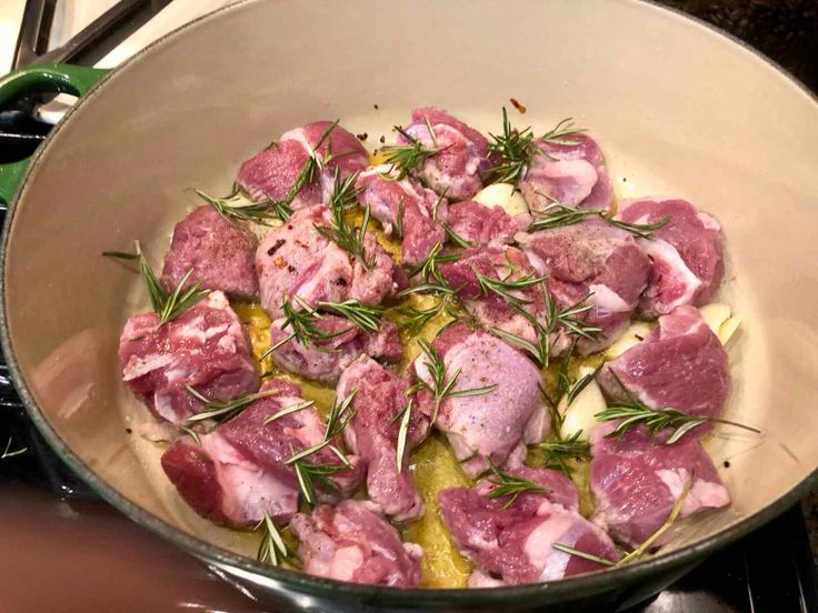 a pan filled with meat and vegetables on top of a stove