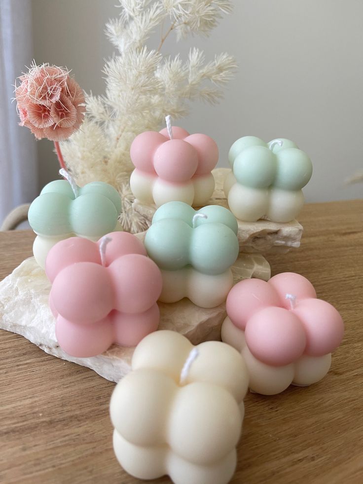 some candles are sitting on a table next to a flower