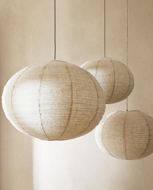 three white paper lanterns hanging from the ceiling