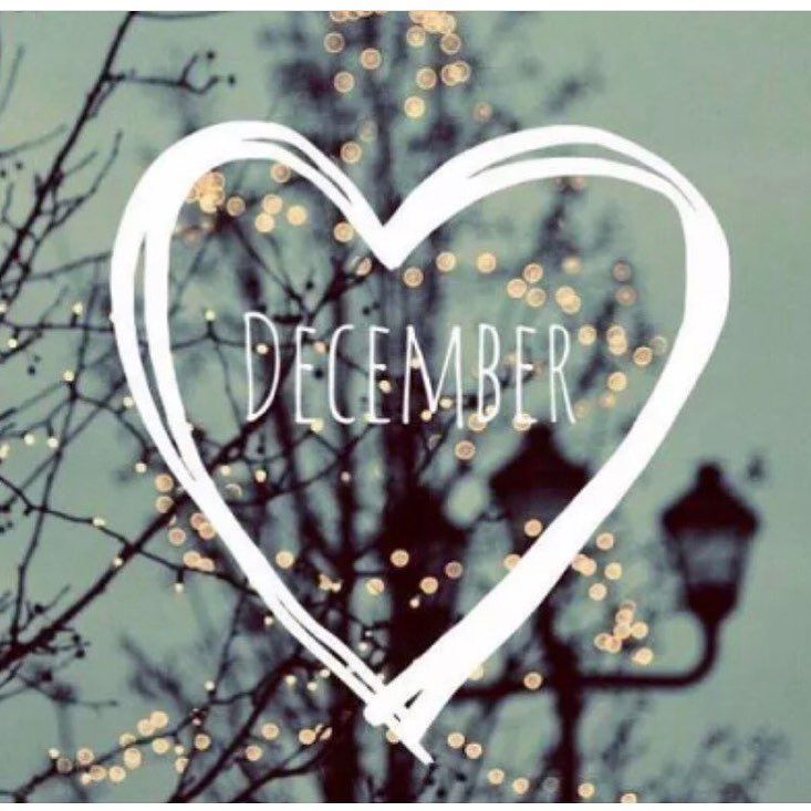 a heart with the words december written on it in front of a tree filled with lights