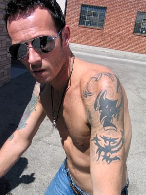 a man with tattoos on his arm riding a bike