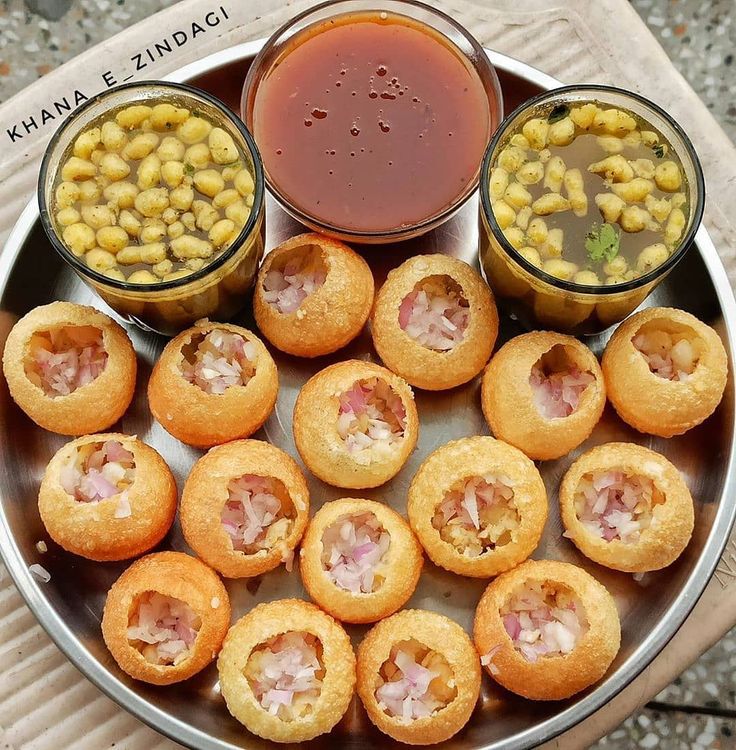 some food is sitting on a plate with sauces and corn in the bowl next to it