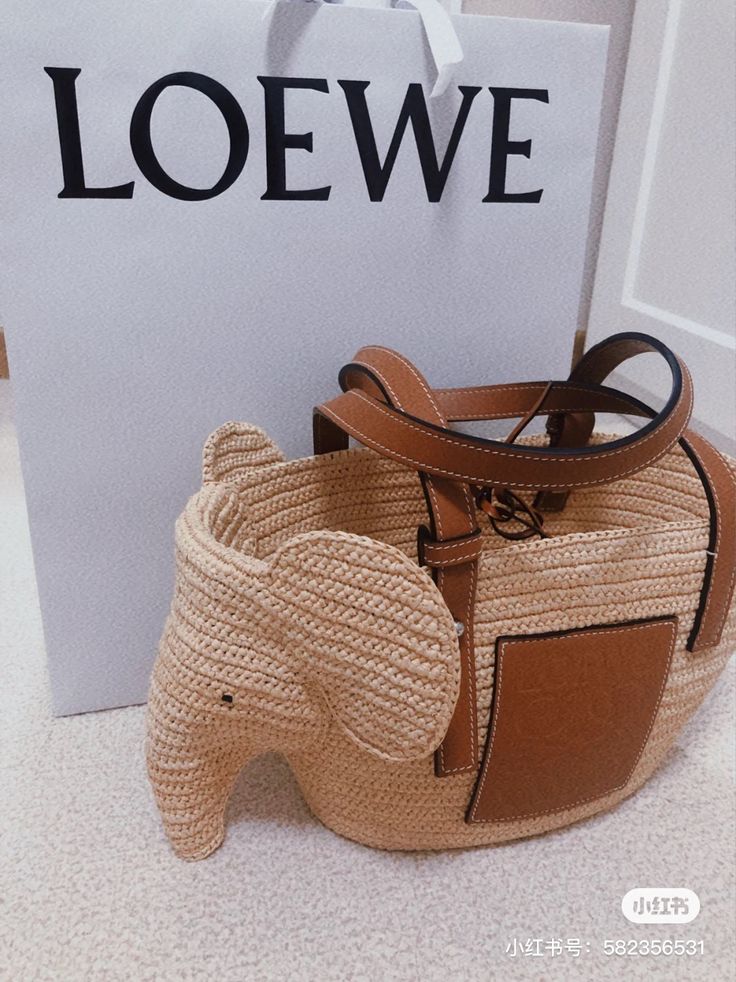 an elephant shaped purse next to a bag with the word loewe on it