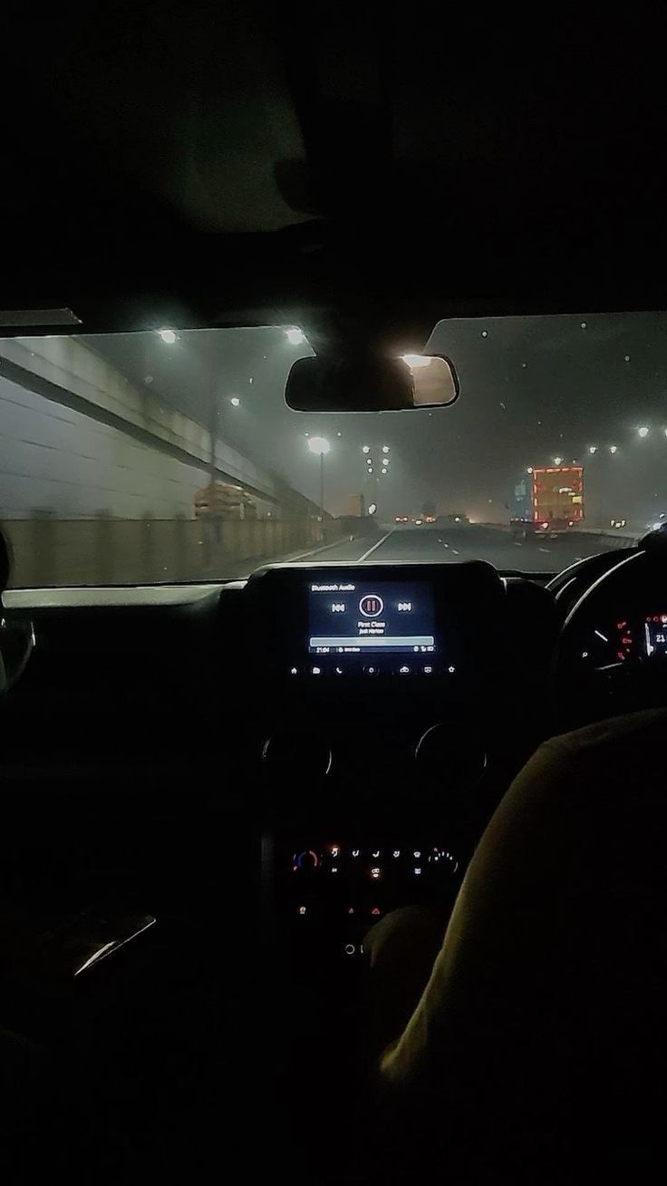 the interior of a car at night, with lights on and fog in the air