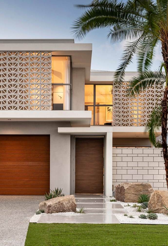 a modern house with a palm tree in the front yard