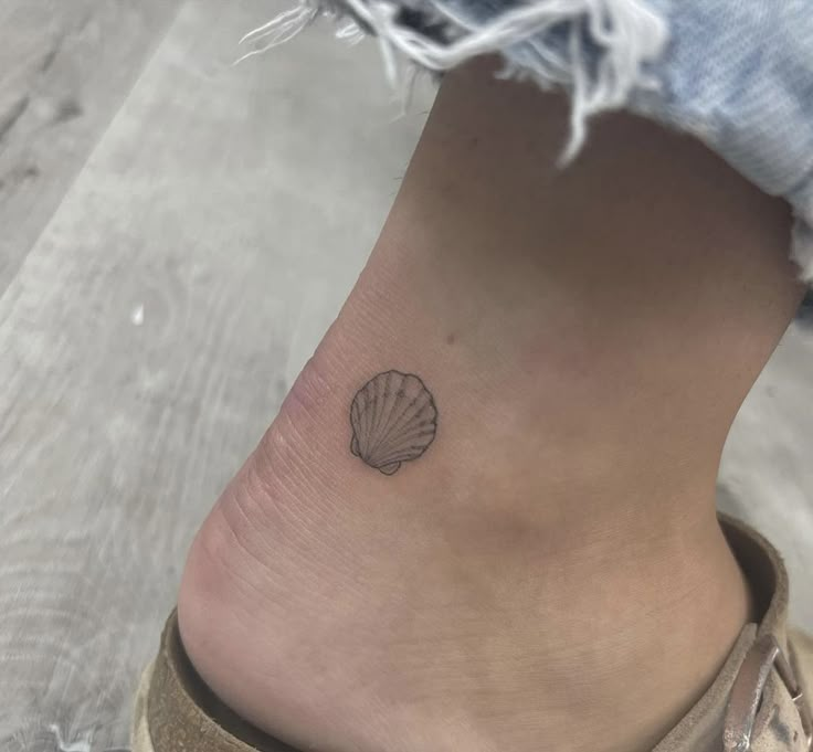 a small seashell tattoo on the ankle