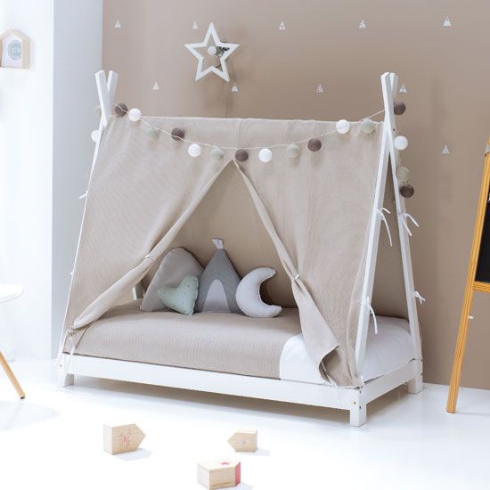 a child's bed with a tent and stars on the wall