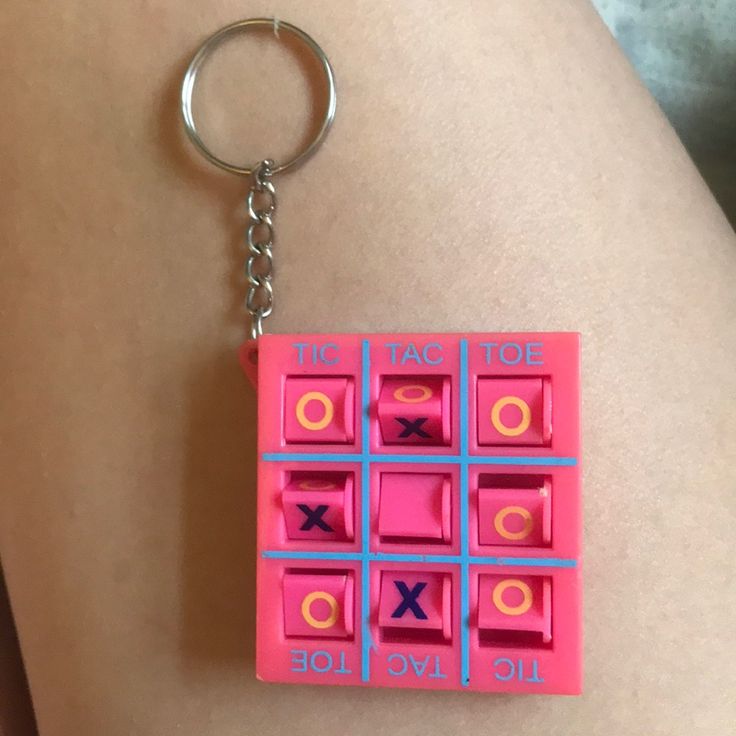 a pink keychain with an xoxo game on it's side