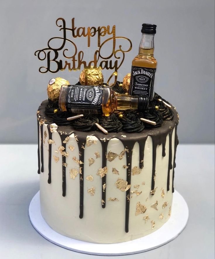 a birthday cake with chocolate icing and gold decorations