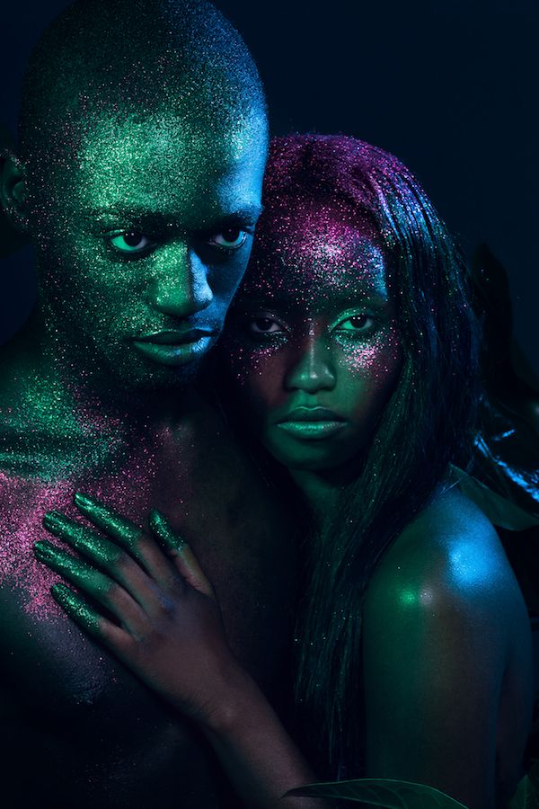 two people covered in green and pink powder posing for the camera with their arms around each other