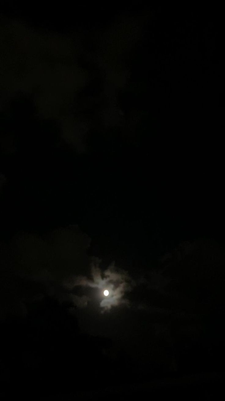 the moon is shining brightly in the dark sky