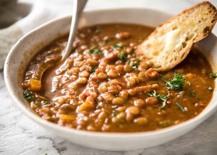 a white bowl filled with beans and bread