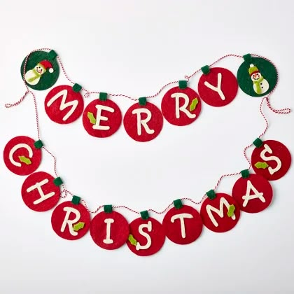 a merry christmas banner with ornaments hanging from it