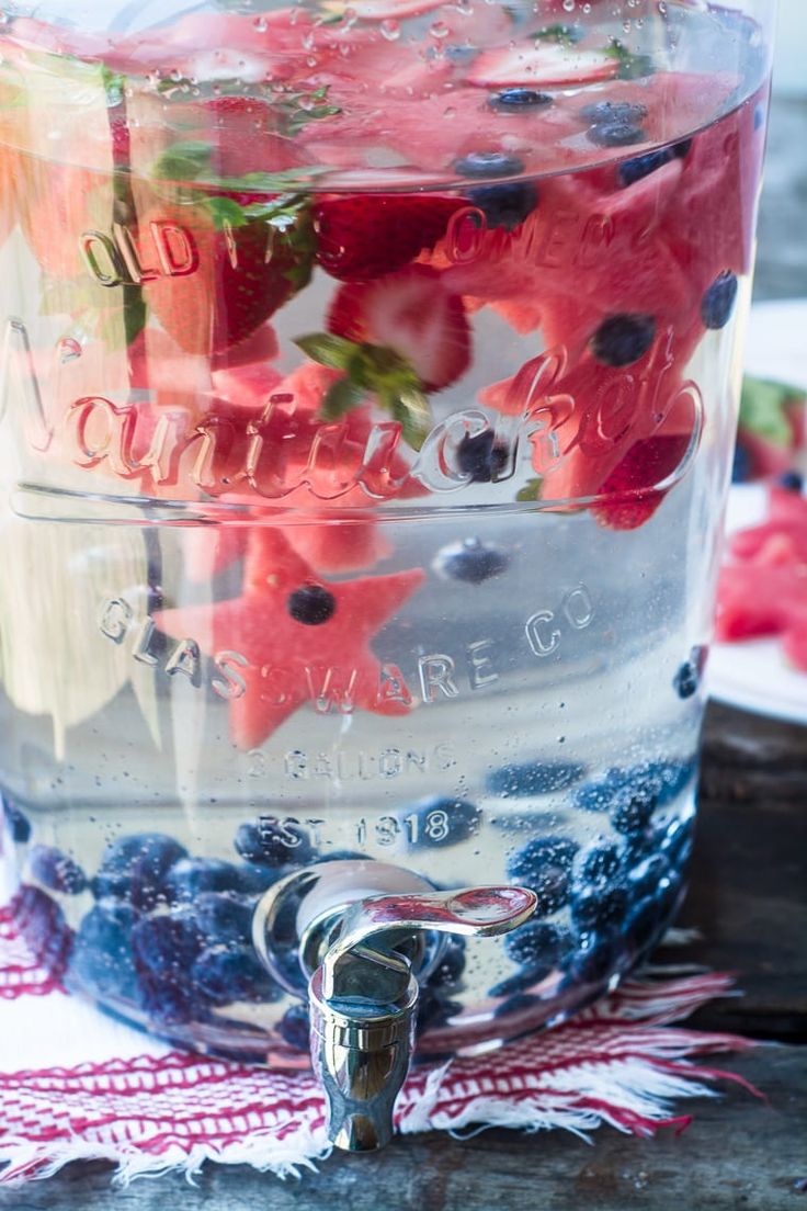 a jar filled with blueberries and strawberries on top of a table