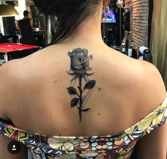 a woman with a black rose tattoo on her back