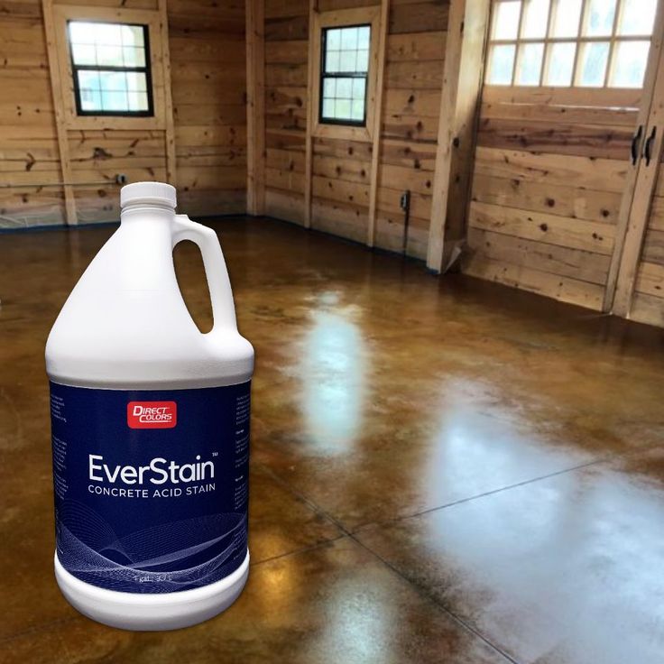 a gallon of everstoin sits on the floor in an empty room with wood paneling