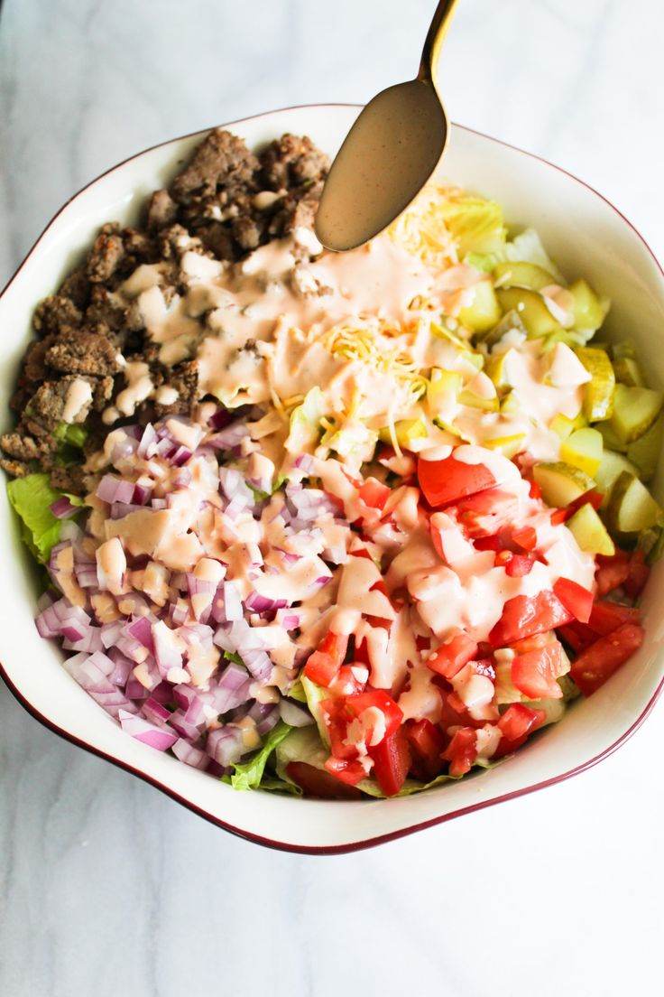 a bowl filled with chopped vegetables and dressing