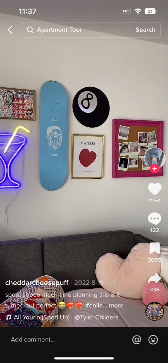 a living room with a couch, skateboard and various pictures on the wall above it