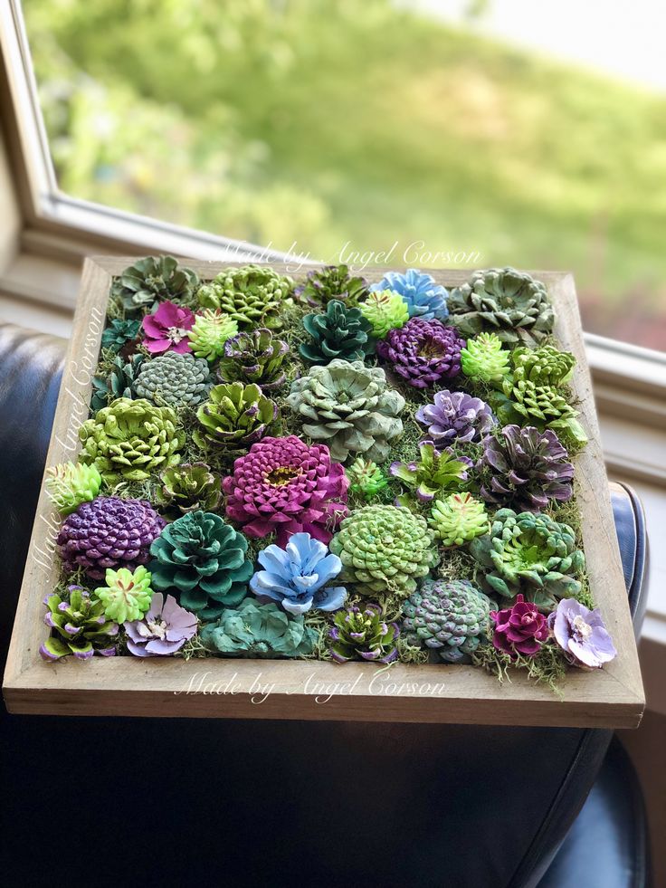 a wooden box filled with succulents sitting on top of a leather chair