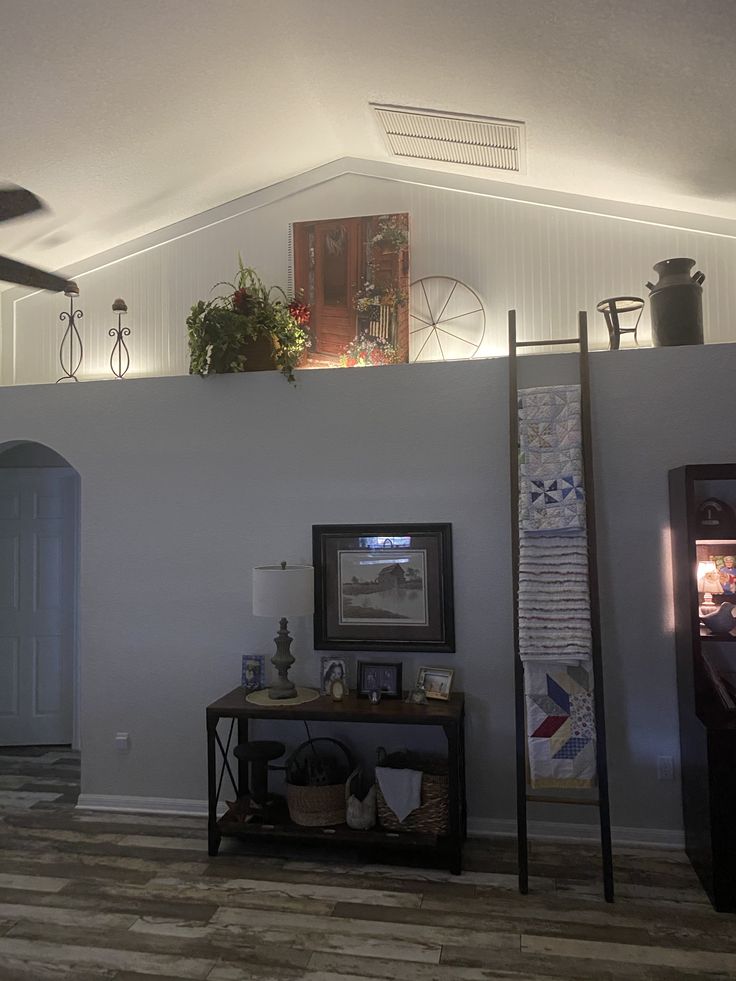 a living room with an entertainment center and ceiling fan