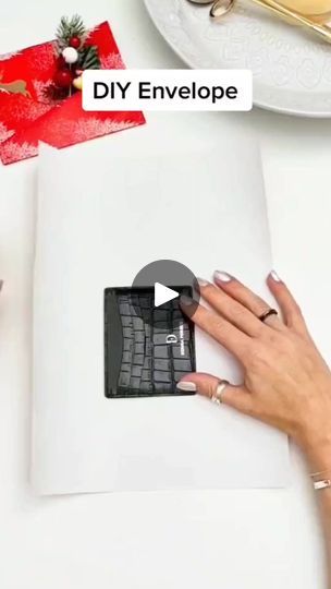 a woman's hand on top of a laptop keyboard next to a christmas present