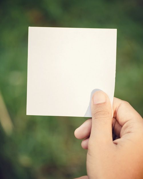 a person holding up a white piece of paper