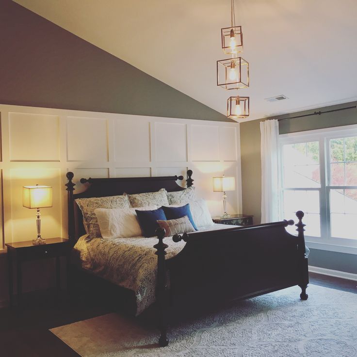 a bedroom with a large bed and two lamps on either side of the headboard