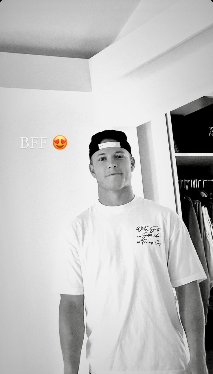 a man standing in front of a mirror wearing a white shirt and black headband