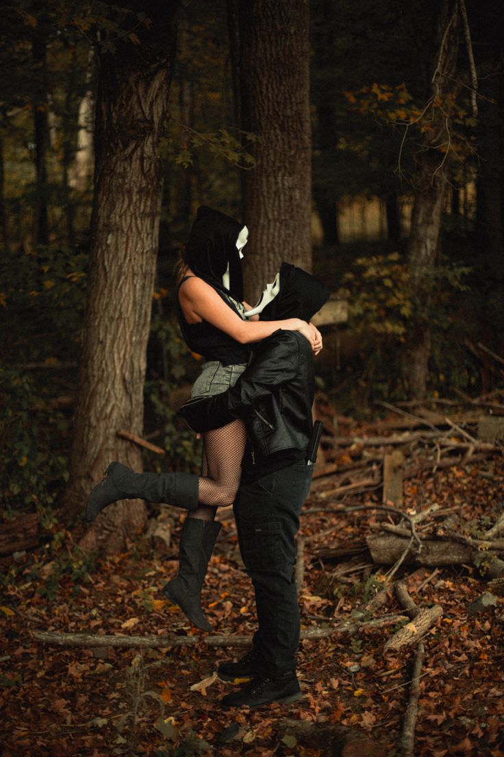 a man carrying a woman in the woods