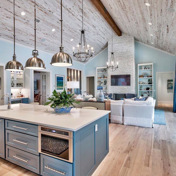 a large open concept kitchen and living room with wood flooring, white walls and ceiling