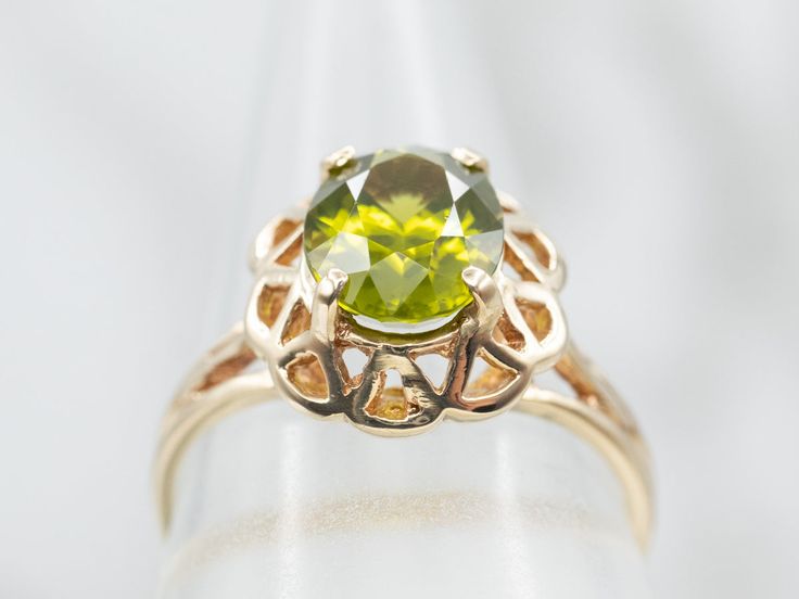 A gorgeous combination of polished gold and a lime green gemstone, these colors play beautifully off each other! The center is an oval-cut peridot, with great depth of color and lovely sparkle. Held in a scalloped filigree setting, the metal work around the stone gives this ring an antique old-world feel.Metal: 10K Yellow GoldGem: Peridot 2.02 CaratsGem Measurements: 6.9 x 8.9 mm, OvalRing Size: 6.50Marks: “B&F 10K” Stamped on the inside band Elegant Lime Green Oval Rings, Oval Peridot Green Jewelry, Oval Green Peridot Jewelry, Green Oval Peridot Jewelry, Green Oval Filigree Ring, Lime Green Oval Jewelry For May Birthstone, Oval Peridot Heirloom Jewelry, Green Oval Filigree Jewelry, Heirloom Peridot Oval Jewelry