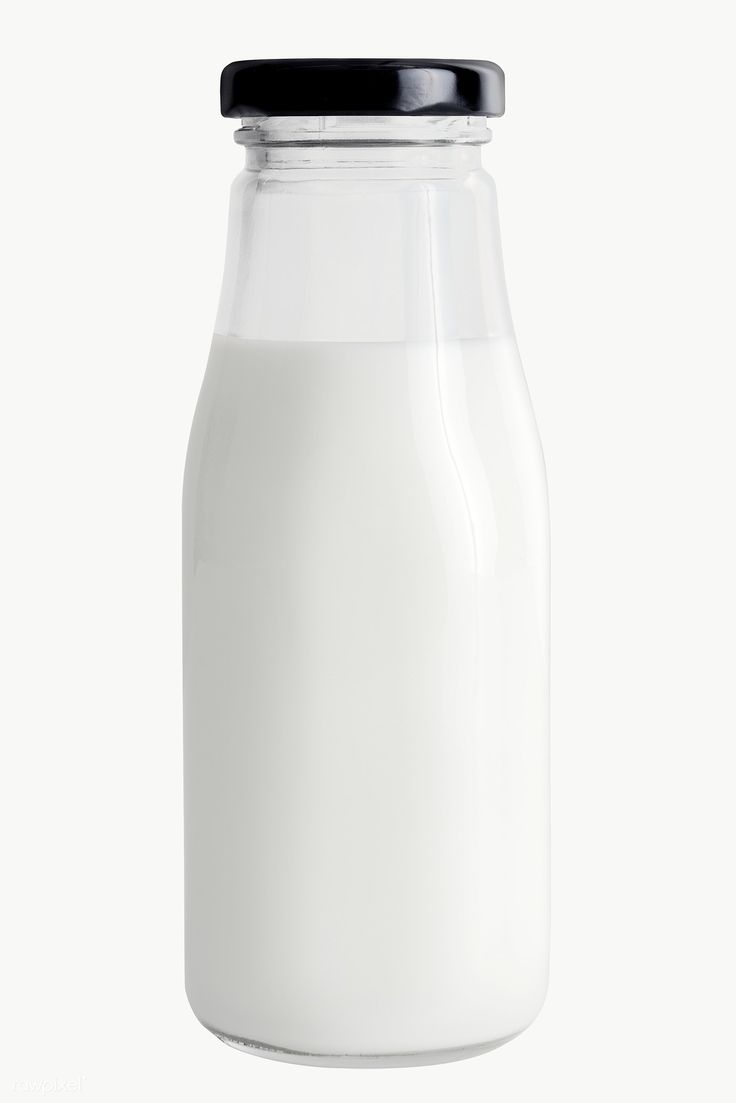 a glass bottle filled with milk on a white background