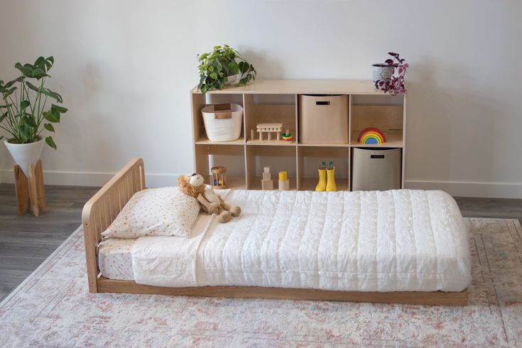 The oak montessori floor bed with one headboard and a six cube shelf in the background Low Floor Bed, Wooden Toddler Bed, Bed Handles, Room Sharing, Modular Bed, Low Profile Bed Frame, Kid's Bed, Toddler Floor Bed, Floor Bed Frame