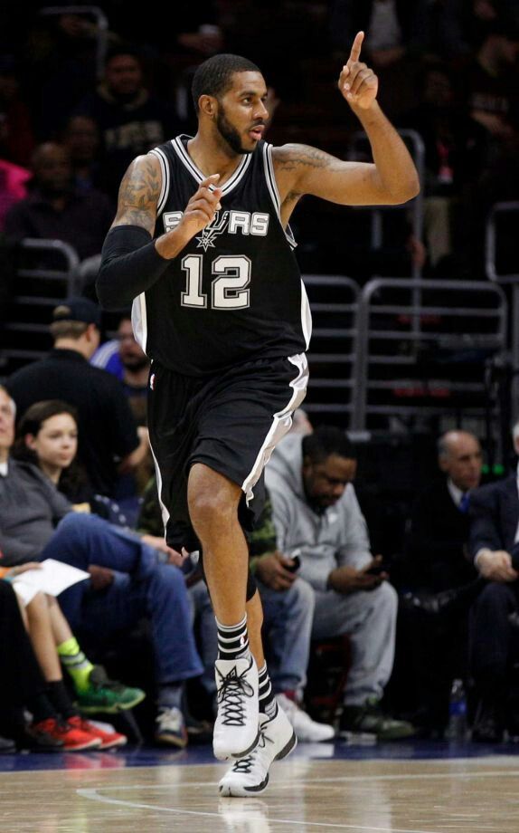 a basketball player running on the court with his hand in the air and one foot up