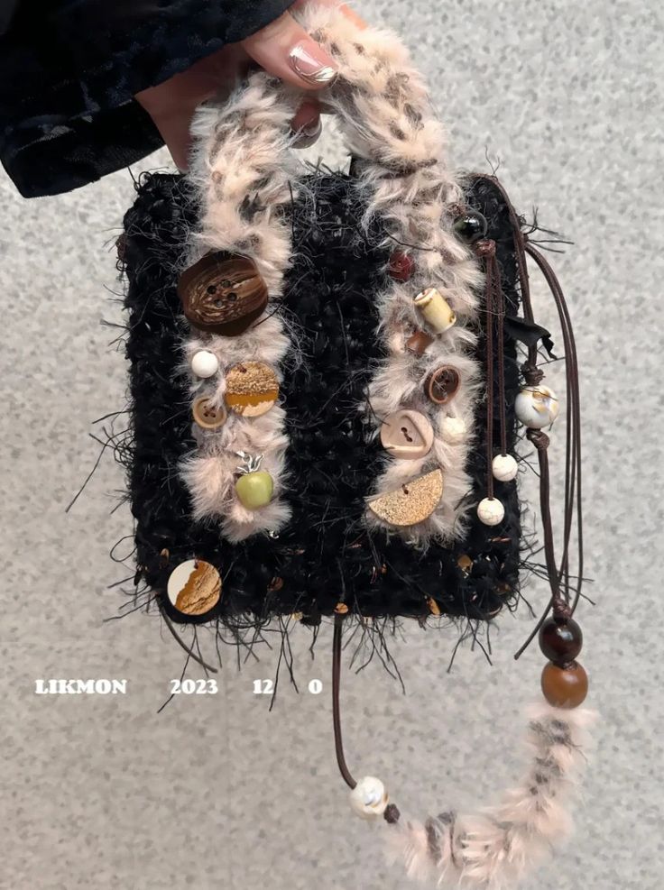 a hand holding a purse with buttons on it