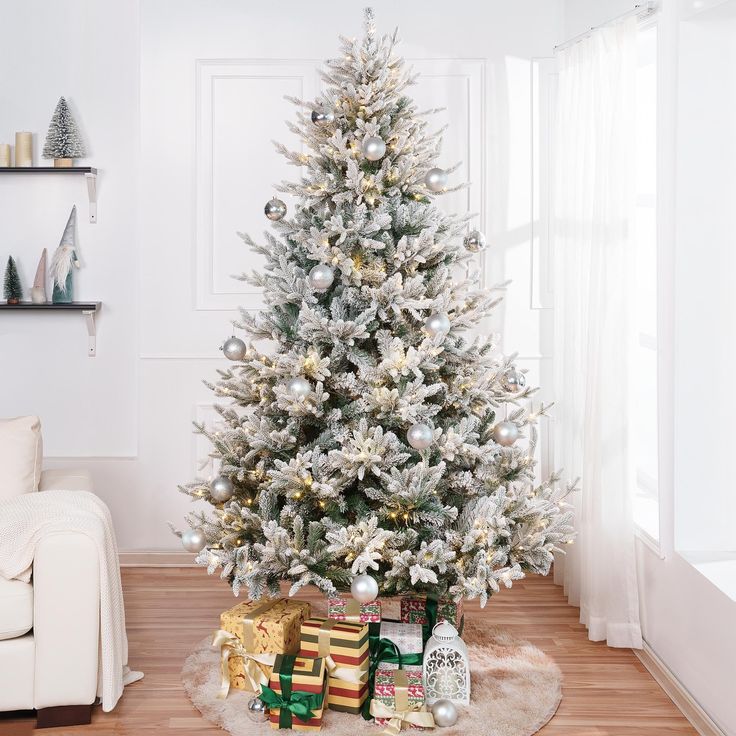 a white christmas tree with presents under it