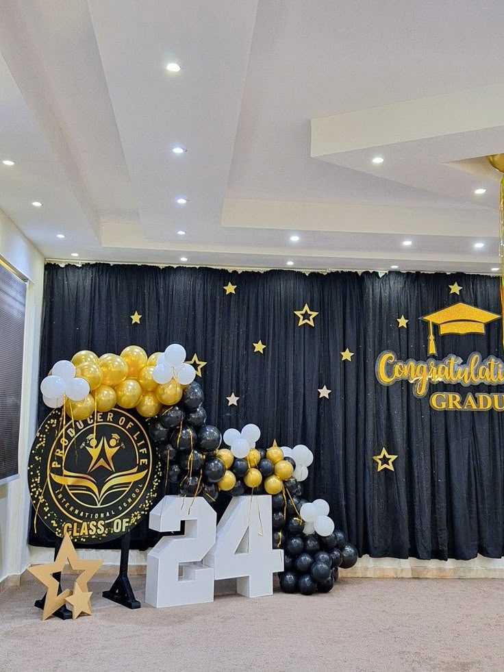 balloons and decorations in front of a backdrop for graduation