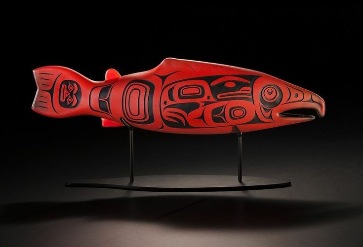 a red and black fish sculpture on a stand