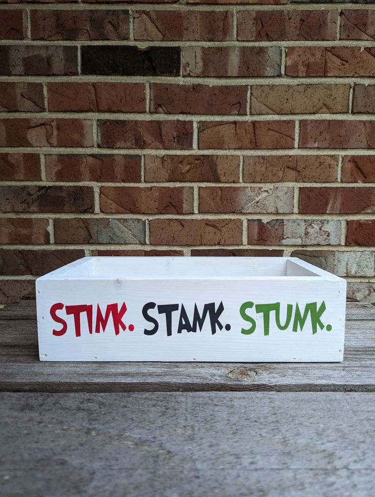 a white box with the words stim stomp on it sitting in front of a brick wall