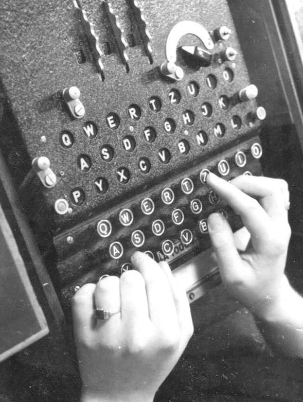 a woman typing on an old typewriter with her hands in the keys and numbers