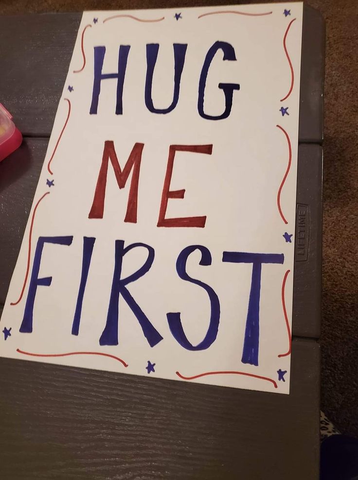 a sign that says hug me first on the floor next to a pair of scissors