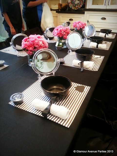 the table is set up with plates and flowers in vases on top of it