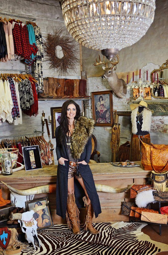 a woman standing in a room with lots of clothes and accessories on the walls,