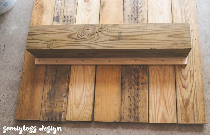 a wooden bench sitting on top of a cement floor