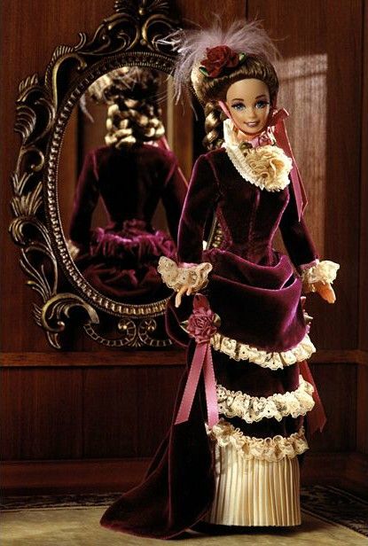 the doll is wearing a purple dress and hat