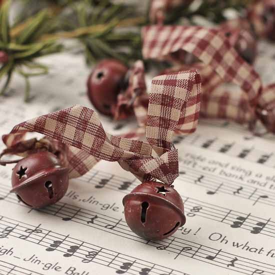 two bells with bows on top of sheet music