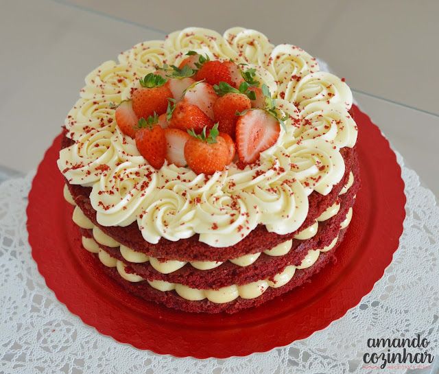 a red velvet cake with white frosting and strawberries on top is sitting on a lace doily