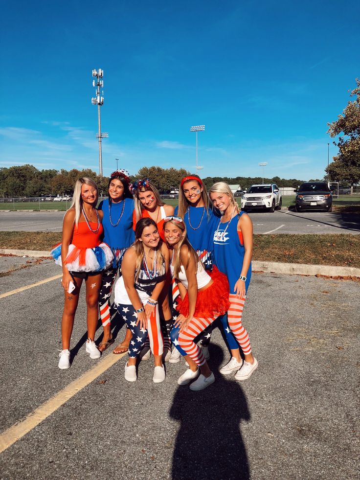 a group of young women standing next to each other on top of a parking lot